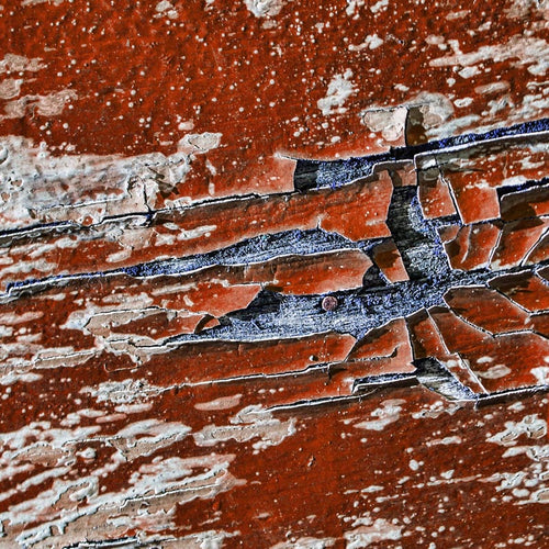 Close-up of a cracked paint texture in red and blue