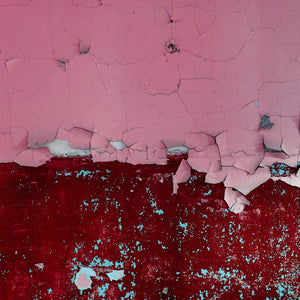 Cracked pink paint over weathered crimson background