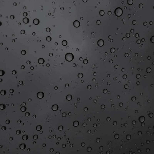 Abstract pattern of water droplets on a dark surface