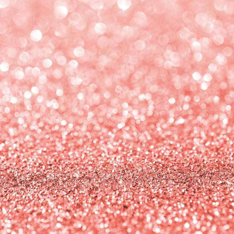 A close-up of a shimmering pink-coral glitter texture