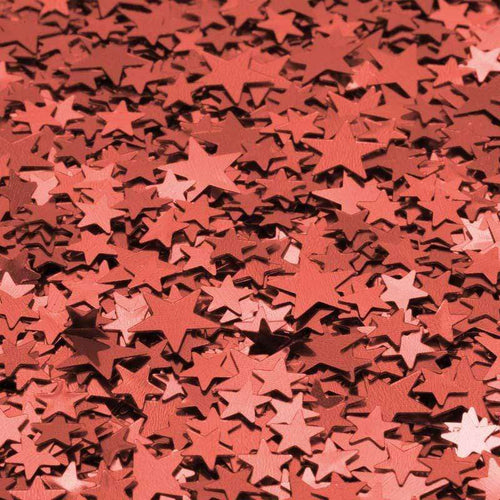 An array of red and pink star-shaped confetti scattered on a surface