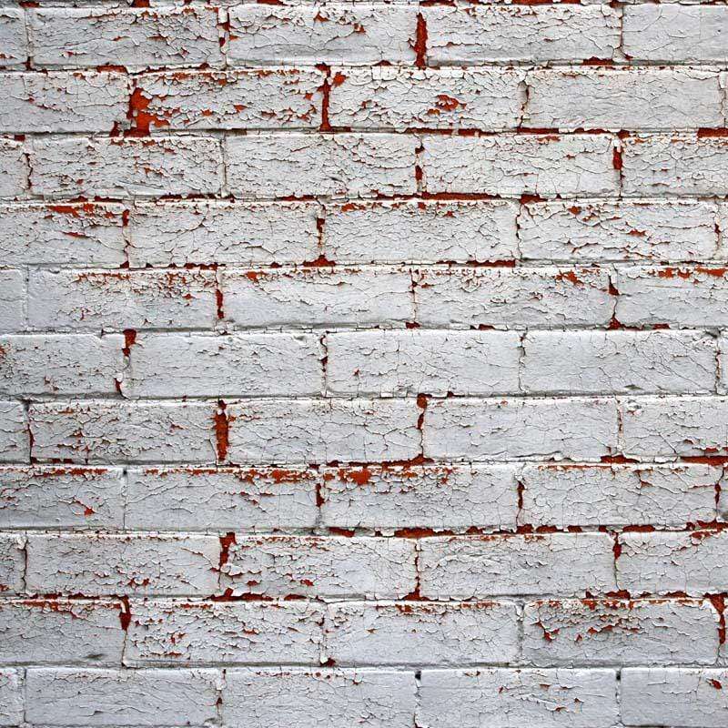 Weathered white painted brick wall with red brick showing through