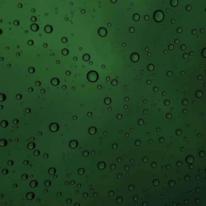 Green water droplets pattern on a window