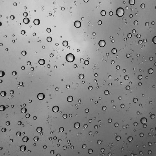 Black and white image of raindrops on a surface