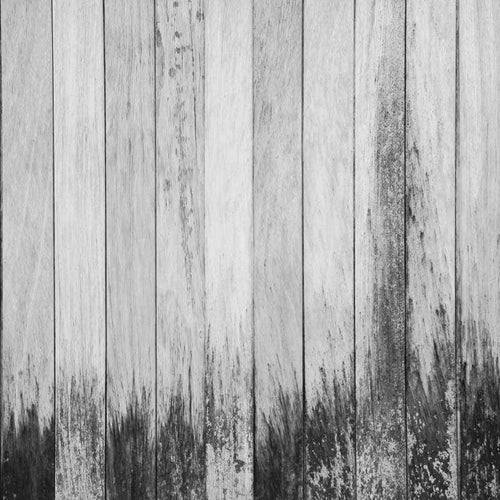 A grayscale image of distressed wooden planks