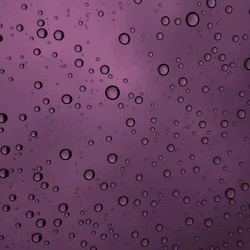 Close-up of water droplets on a smooth purple surface