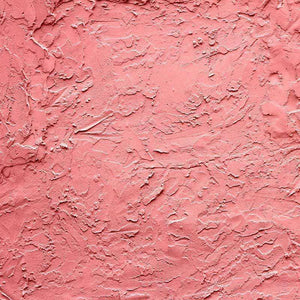 Close-up of a textured coral pink plaster pattern