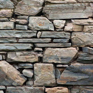 Close-up of a stone wall with varied sizes of flat stones
