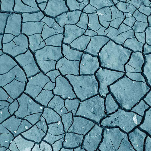 A textured pattern of cracked blue clay